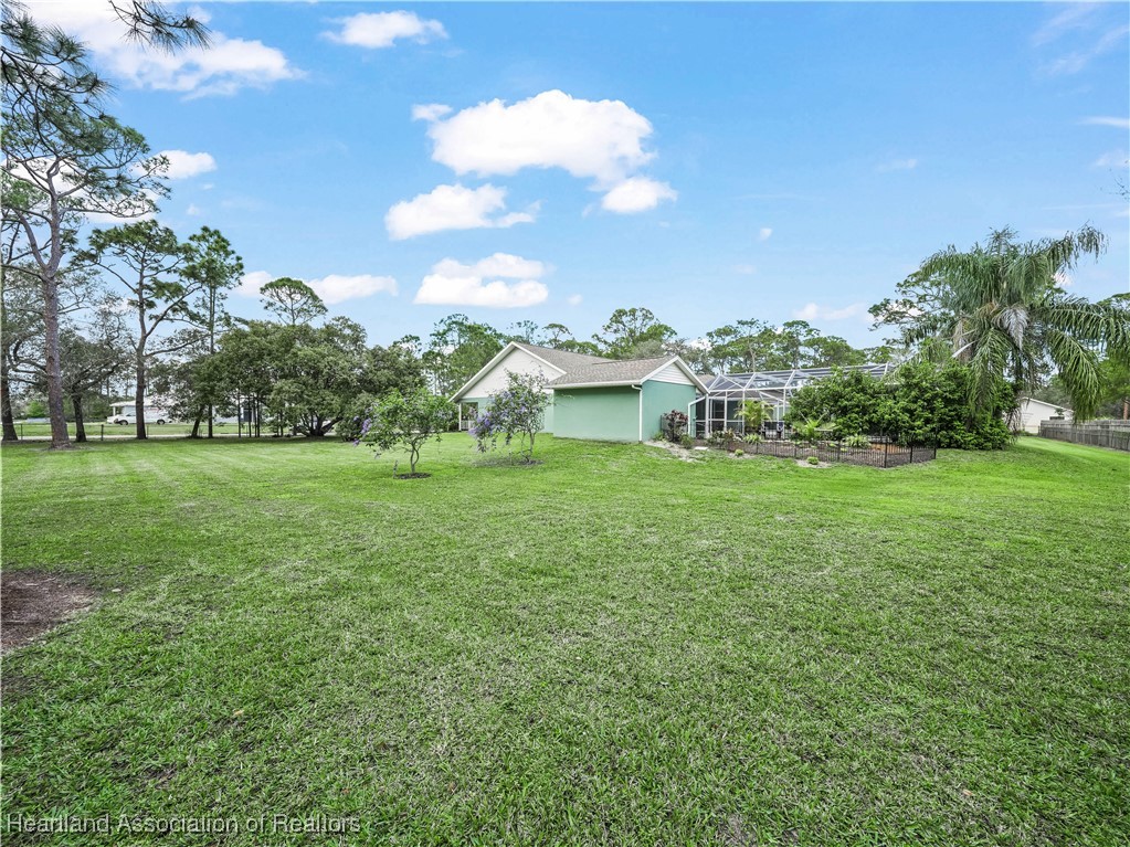 5342 Lime Road Sebring, FL 33875 - Photo 42 of 47 SOUTH SIDE OF BACK YARD AND HOUSE, POOL HOUSE AND POOL AREA