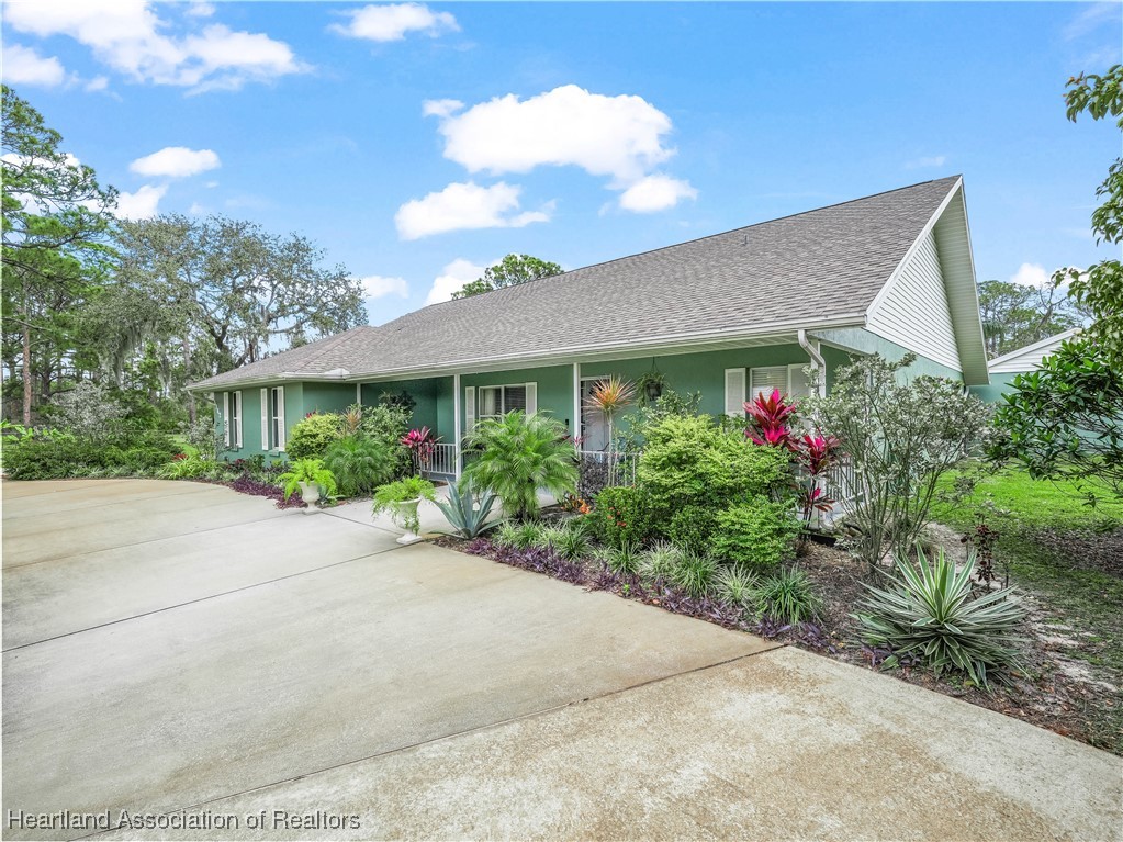 5342 Lime Road Sebring, FL 33875 - Photo 7 of 47 A FULLY FENCED YARD WITH FLOWERING TREES AND DECORATIVE LANDSCAPING