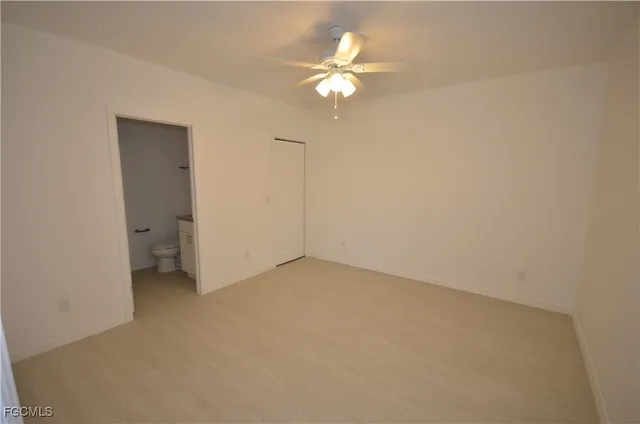 a view of an empty room with a chandelier fan