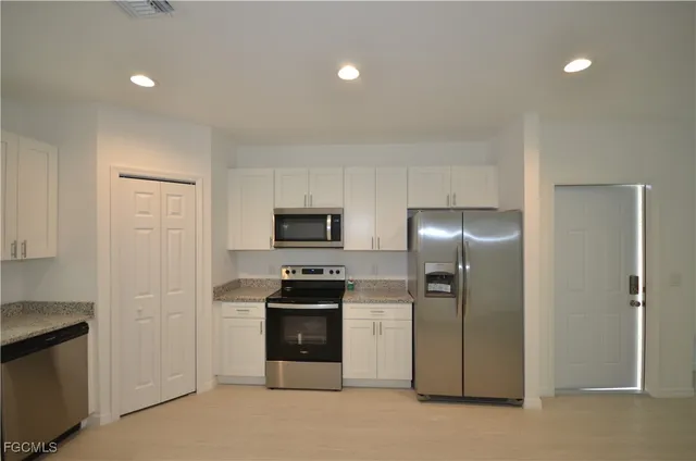 a kitchen with stainless steel appliances a refrigerator and a stove top oven