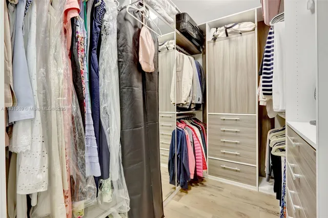 a view of walk in closet with clothes
