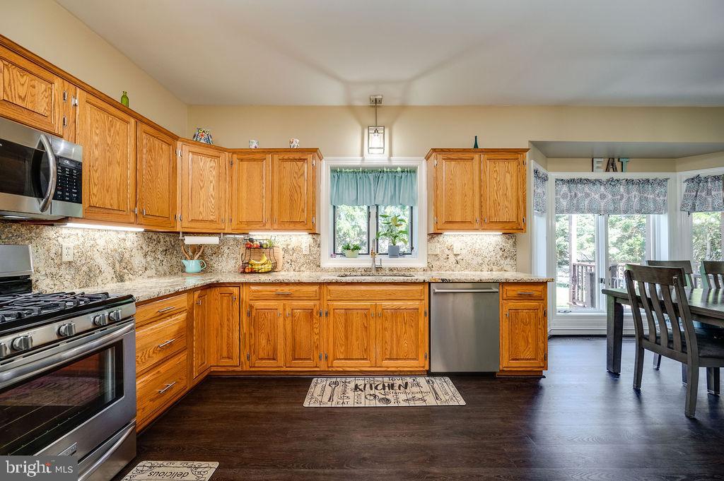 24 Sycamore Drive Reading, PA 19606 - Photo 19 of 56 a kitchen with granite countertop a stove top oven a sink dishwasher and cabinets with wooden floor