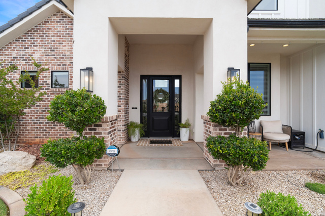 2278 Tawny Ridge Circle St. George, UT 84790 - Photo 3 of 61 Entryway featuring a dark paneled door with glass inserts, flanked by matching exterior sconces.