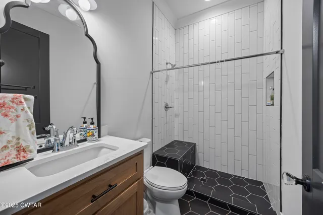 a bathroom with a sink a toilet and a mirror