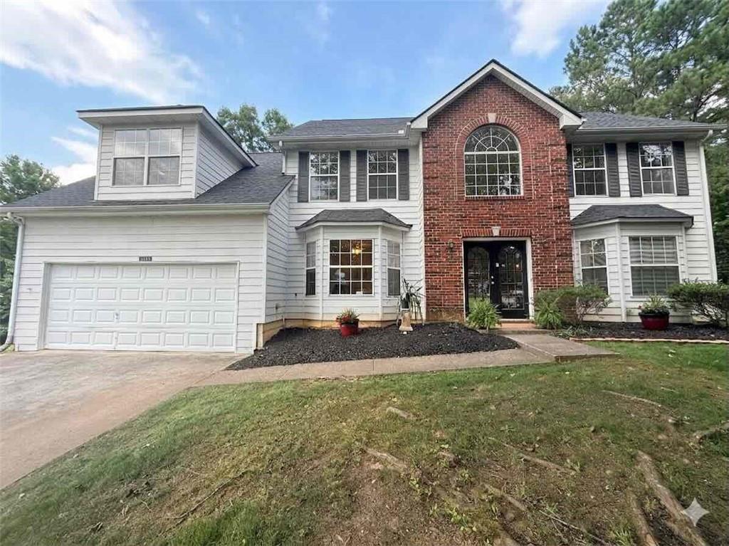 3234 Mineral Ridge Lane Stone Mountain, GA 30087 - Photo 1 of 55 a front view of a house with a yard and garage