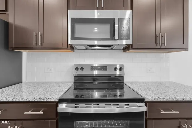 a kitchen with stainless steel appliances granite countertop a sink stove and microwave