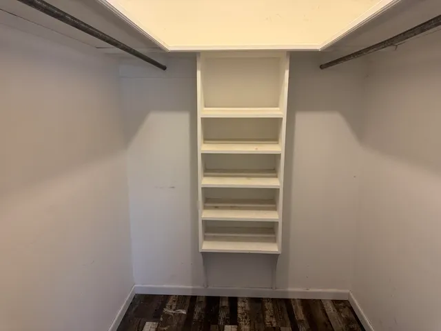 a view of a room with wooden floor and windows