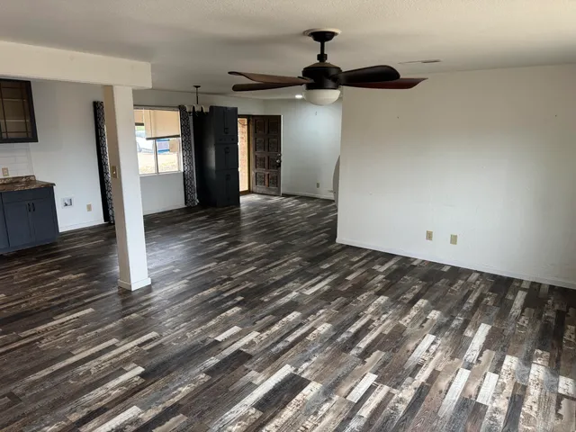 a view of a hallway view with wooden floor and a ceiling fan