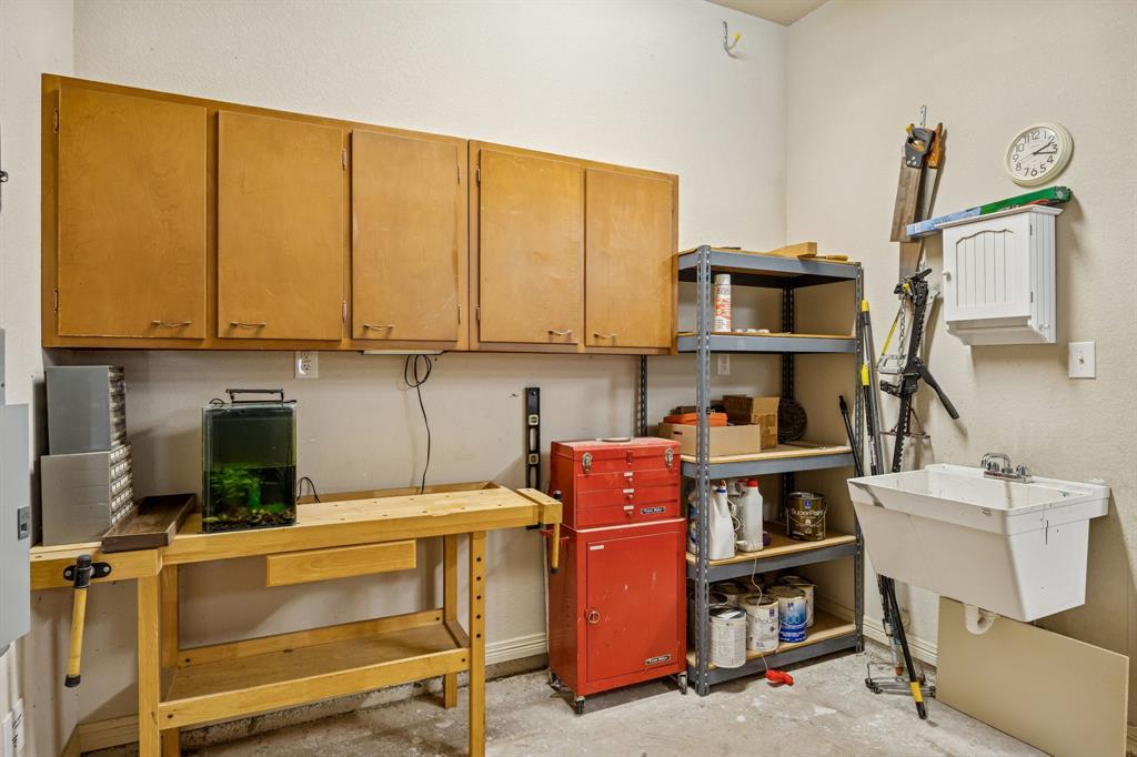 1520 Snider Court Lucas, TX 75002 - Photo 37 of 40 Workbench area in garage with built in upper cabinets and a sink.