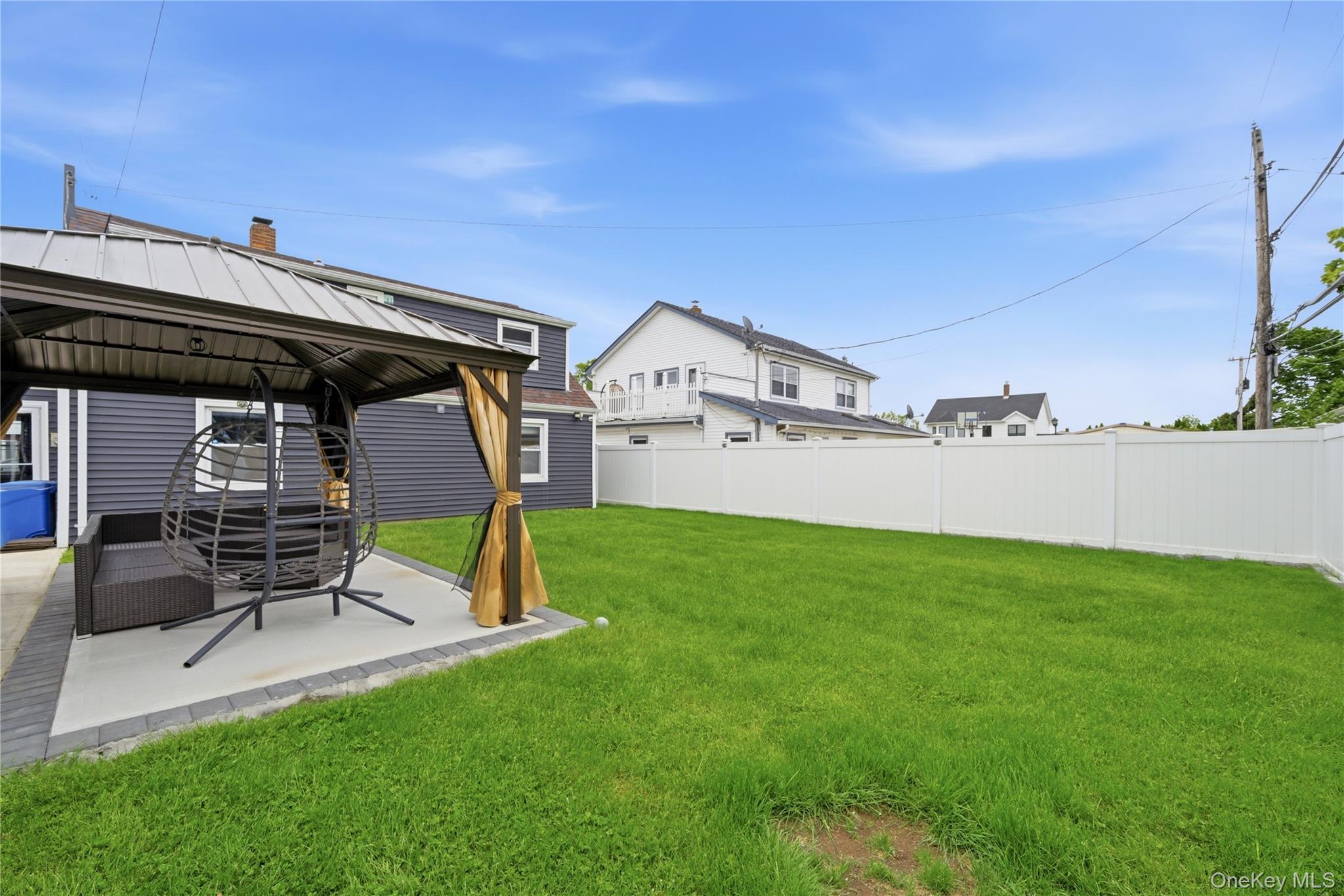 50 Ridge Lane Levittown, NY 11756 - Photo 26 of 27 a view of a chairs and table in the back yard of the house