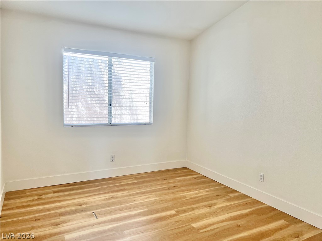 9708 Ridge Creek Place Las Vegas, NV 89134 - Photo 22 of 34 3rd Bedroom. A well-lit room showcases durable lvp flooring and a large window, offering versatility for various uses.
