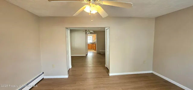 a view of an empty room with wooden floor