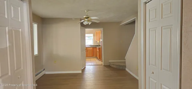 an empty room with wooden floor and windows