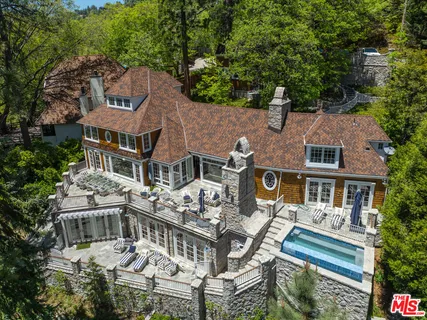an aerial view of a house with balcony and trees al around