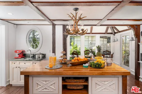 a kitchen with a table and a vase of flowers on it
