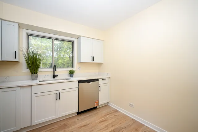 a kitchen with a sink cabinets and window