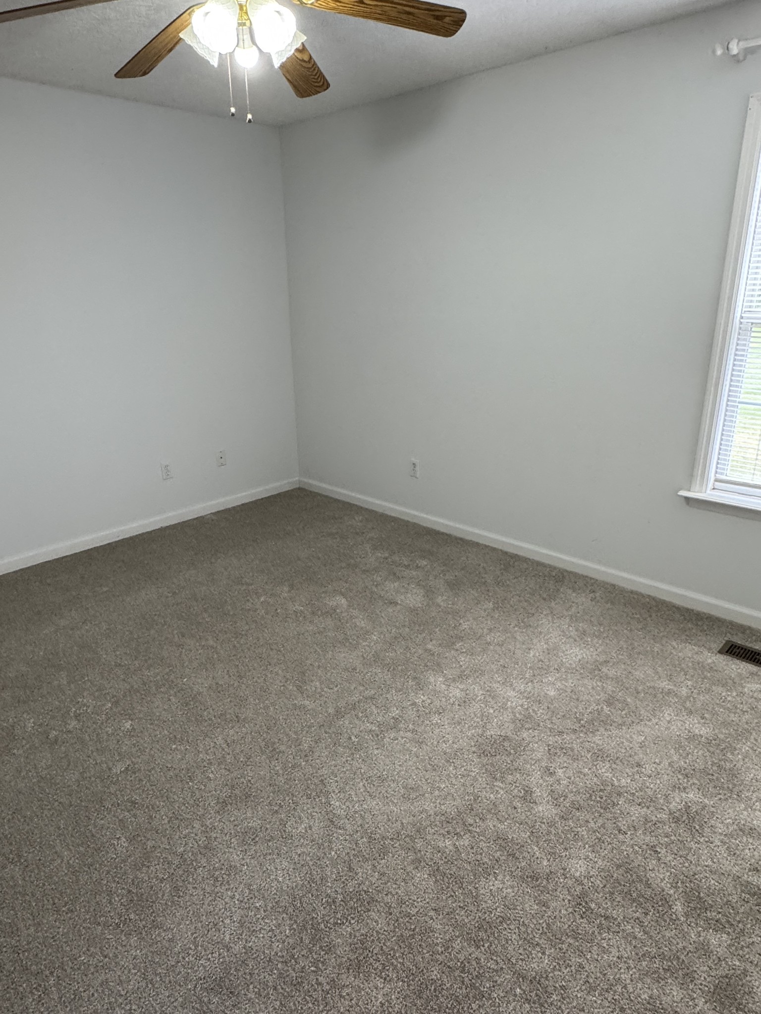 354 Spring Creek Road Lafayette, TN 37083 - Photo 12 of 14 an empty room with a chandelier fan and window