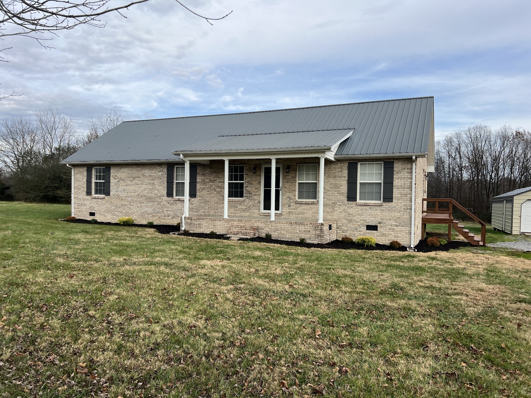 354 Spring Creek Road Lafayette, TN 37083 - Photo 2 of 14 a front view of a house with a garden