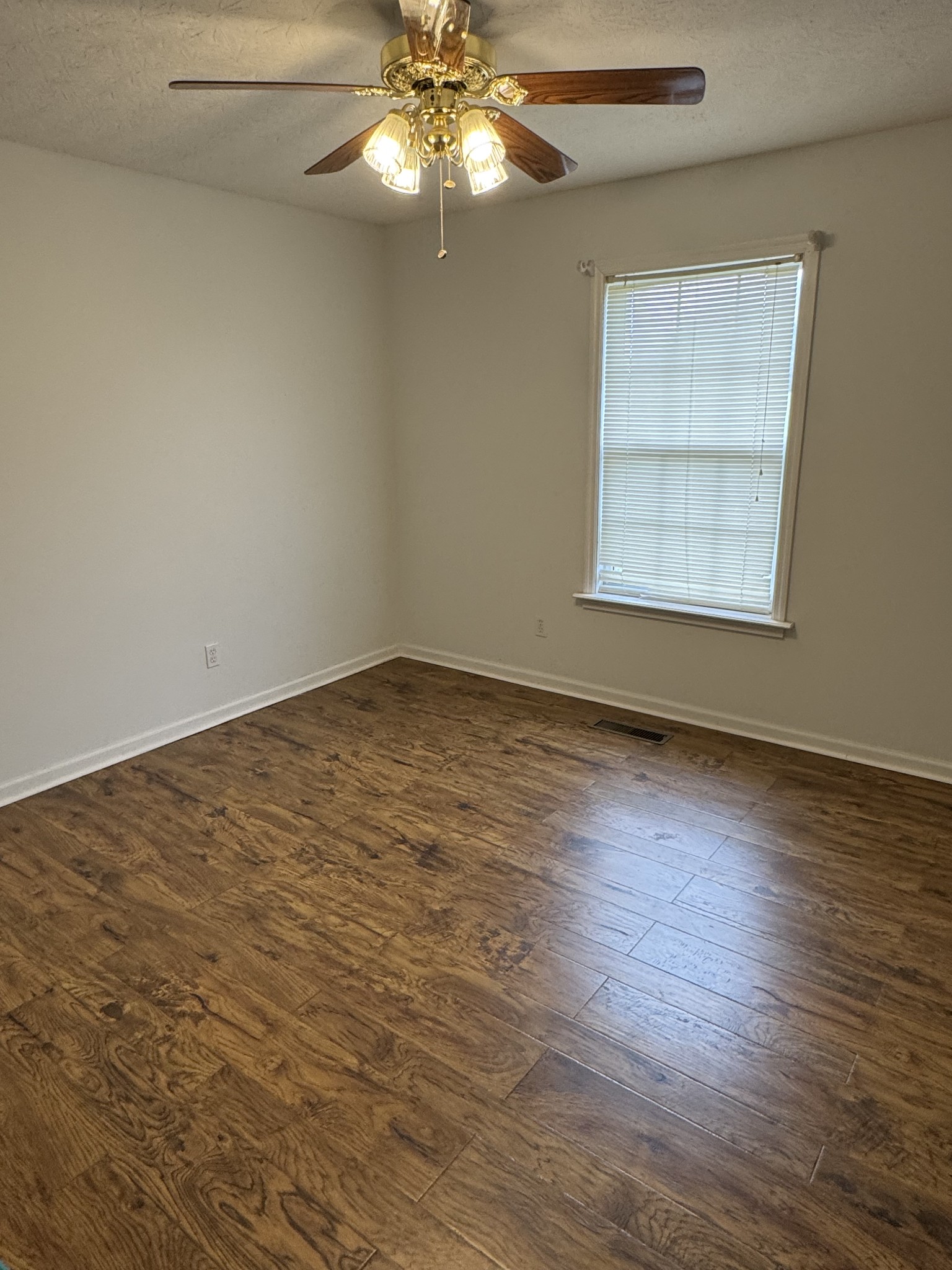 354 Spring Creek Road Lafayette, TN 37083 - Photo 9 of 14 an empty room with wooden floor fan and windows