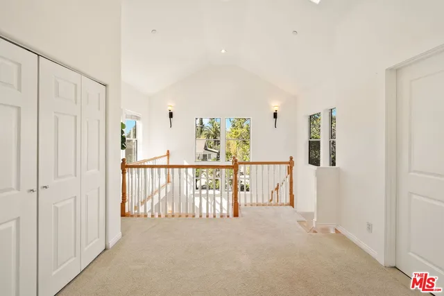 a kitchen with stainless steel appliances granite countertop a stove a sink a refrigerator a microwave oven with white cabinets and wooden floor