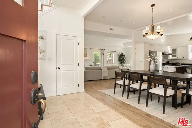 a view of a dining room and livingroom with furniture wooden floor a chandelier