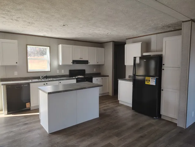 a kitchen with stainless steel appliances granite countertop a refrigerator and a stove top oven