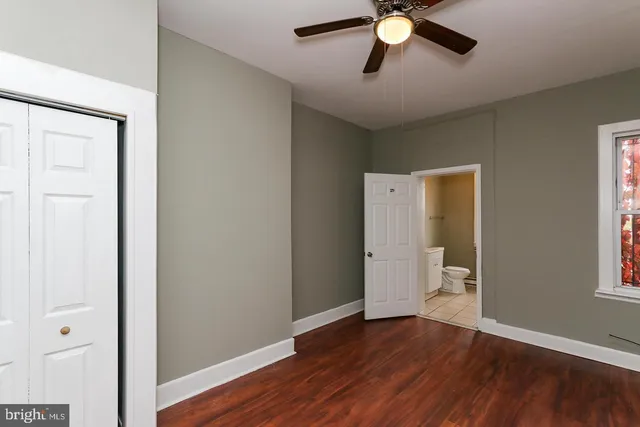 an empty room with wooden floor and entrance