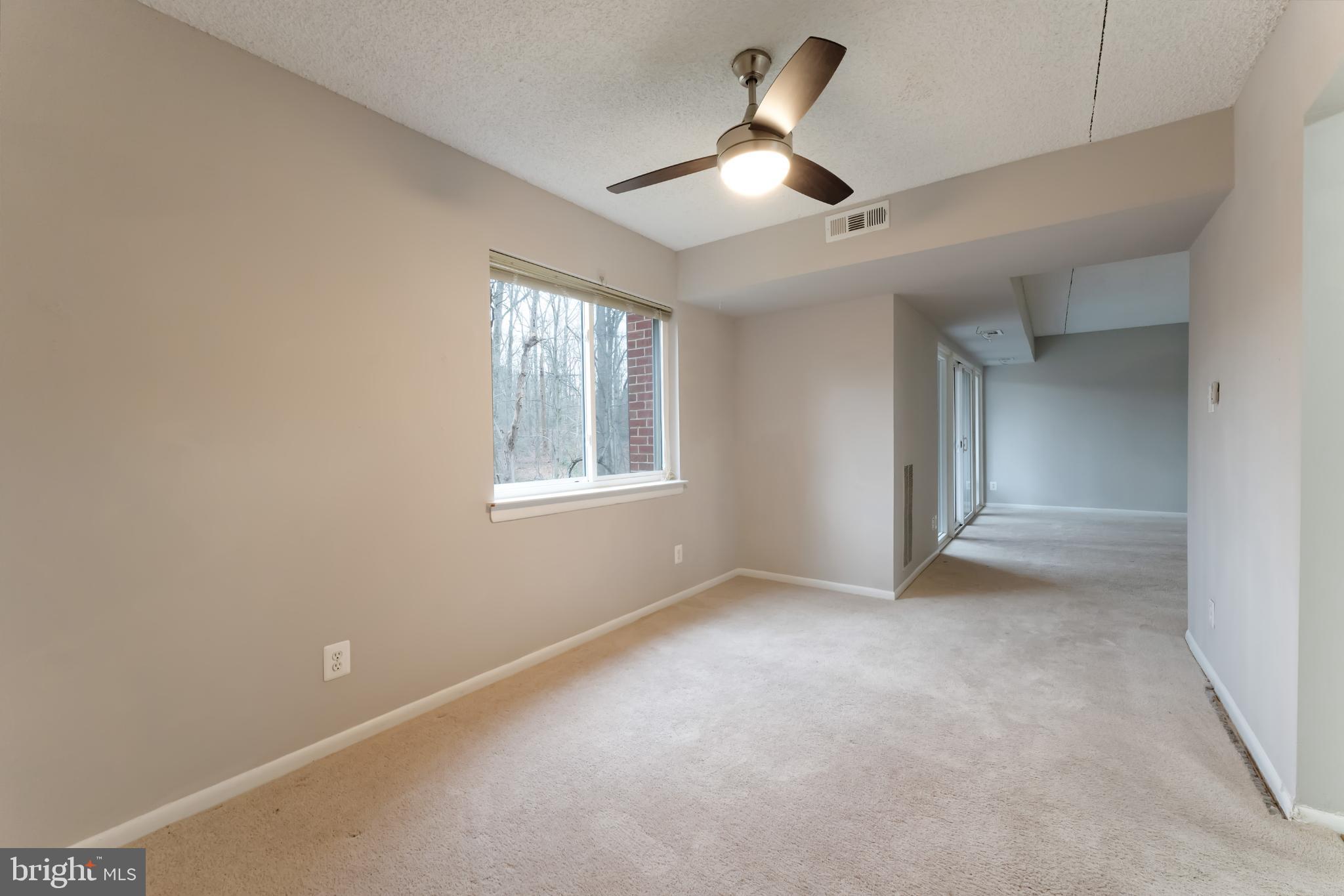 11833 Shire Court, Unit 11B Reston, VA 20191 - Photo 11 of 29 en empty room with windows and ceiling fan