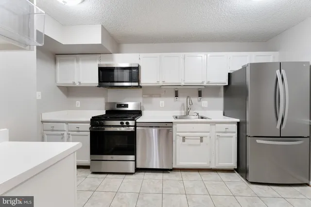 a kitchen with stainless steel appliances granite countertop a stove a refrigerator and a microwave