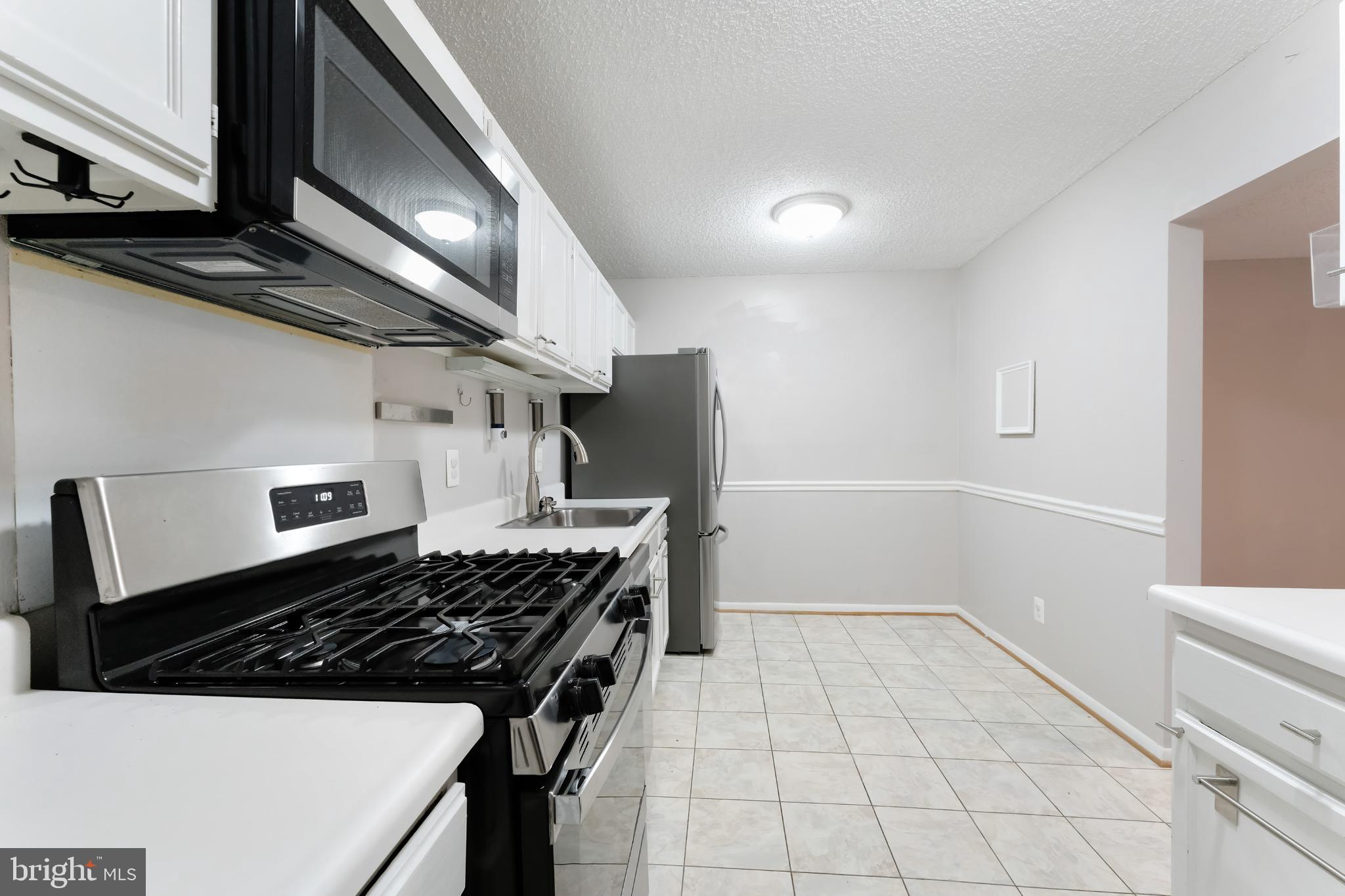11833 Shire Court, Unit 11B Reston, VA 20191 - Photo 6 of 29 a kitchen with a sink a stove and refrigerator