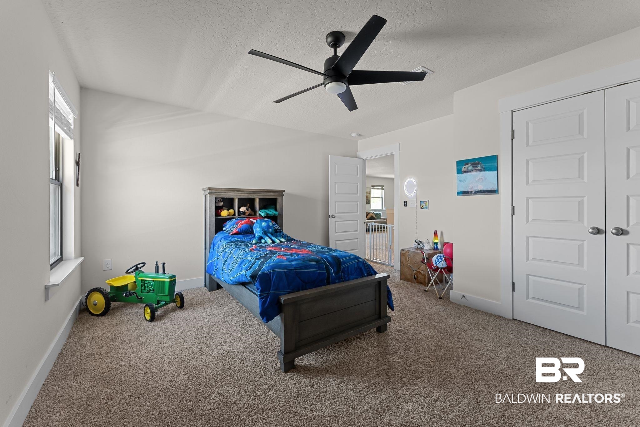16607 Prado Loop Loxley, AL 36551 - Photo 28 of 46 Carpeted room featuring a ceiling fan, two-panel interior doors, and a window with a white sill