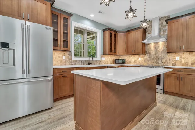 a kitchen with stainless steel appliances granite countertop a sink stove and refrigerator