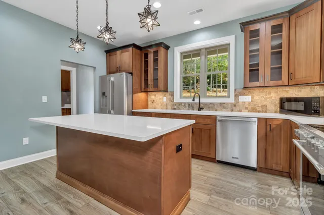 a kitchen with kitchen island granite countertop a sink window and stainless steel appliances