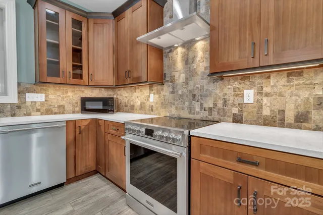 a kitchen with stainless steel appliances granite countertop a sink stove and cabinets