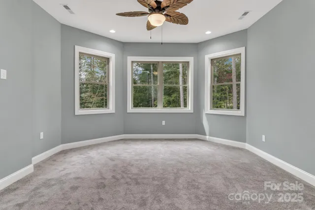 an empty room with a window and a ceiling fan