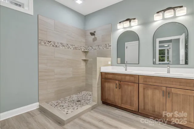 a bathroom with double vanity sinks and a mirror
