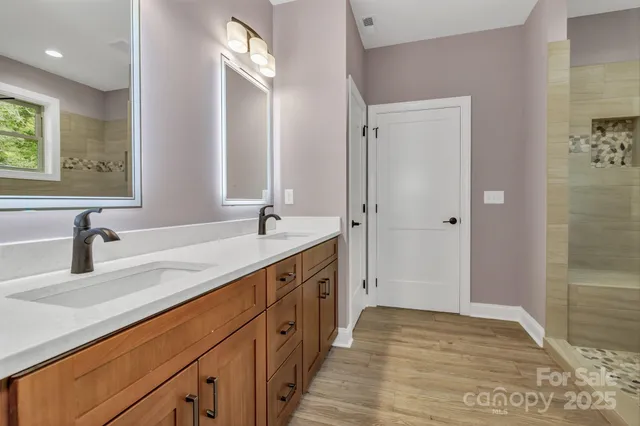 a bathroom with a double vanity sink a mirror and a shower