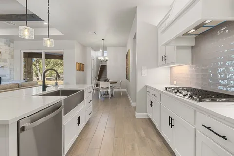 a kitchen with white cabinets and appliances