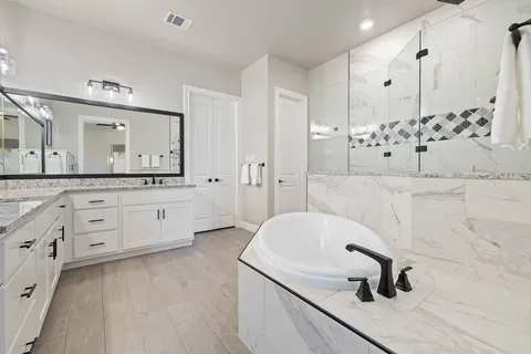 a bathroom with a tub sink and mirror