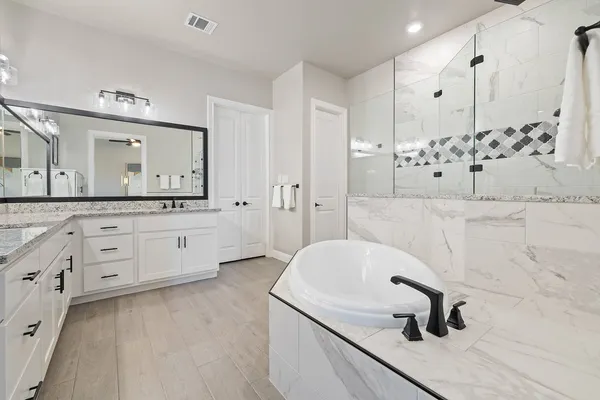 a bathroom with a tub sink and mirror