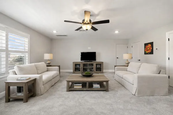 a living room with furniture a flat screen tv and a window