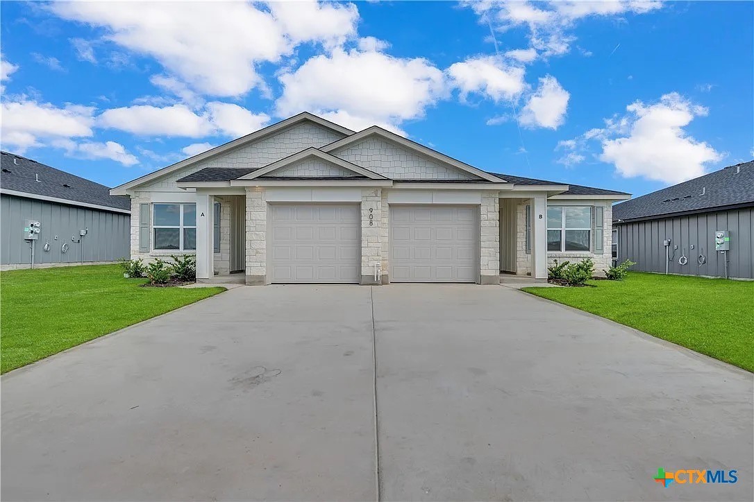 a view of a house with a yard and large tree