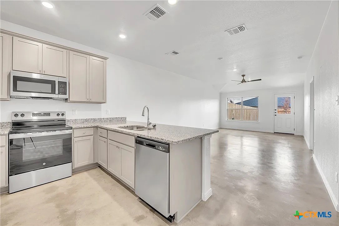 908 Smoke Tree Lane, Unit B Killeen, TX 76543 - Photo 3 of 13 a kitchen with stainless steel appliances granite countertop a stove top oven a sink dishwasher and a refrigerator with wooden floor