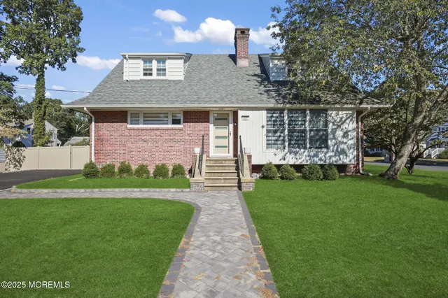 a front view of a house with a garden and yard