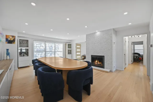 a living room with a fireplace a flat screen tv and kitchen view