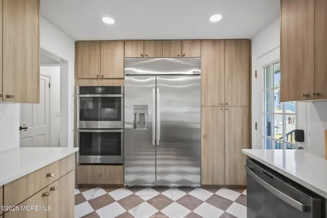 a kitchen with granite countertop a refrigerator and a sink