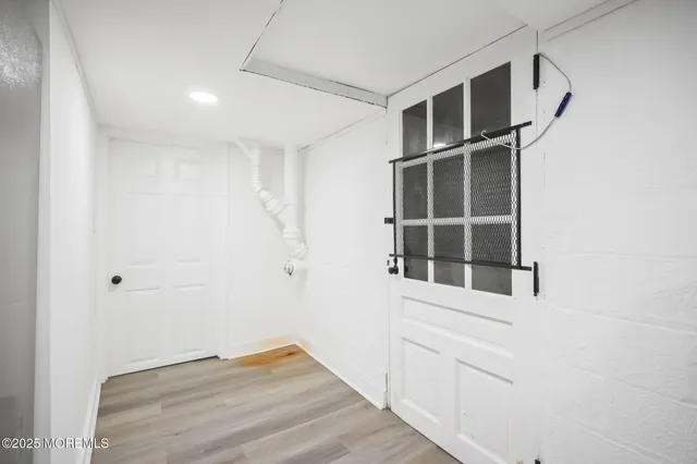 a view of an empty room with wooden floor and cabinet