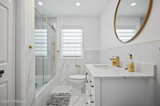 a bathroom with a sink a mirror a toilet and a shower