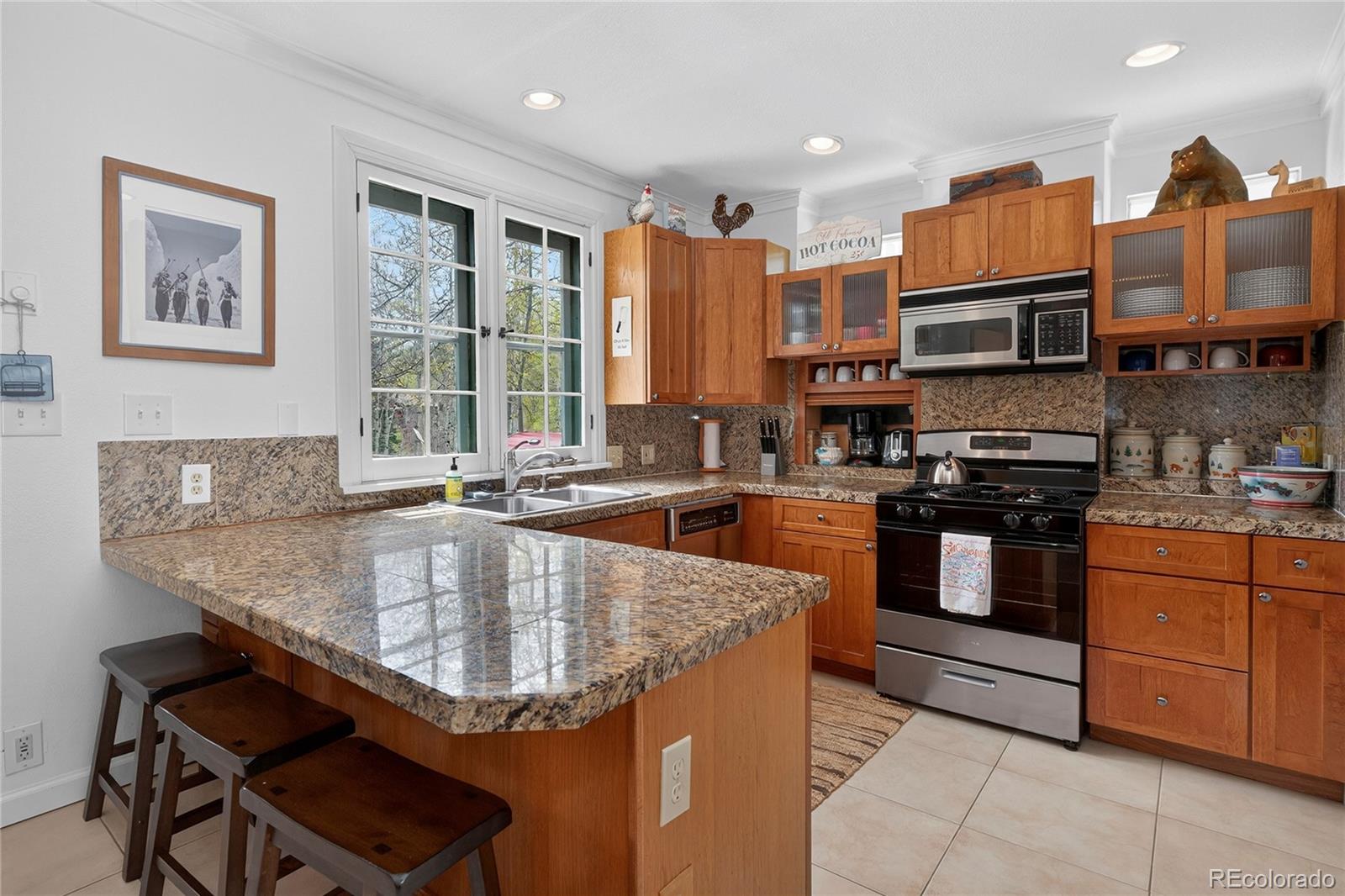 327 Vasquez Road, Unit E1 Winter Park, CO 80482 - Photo 31 of 43 a kitchen with stainless steel appliances granite countertop a sink a stove and a refrigerator