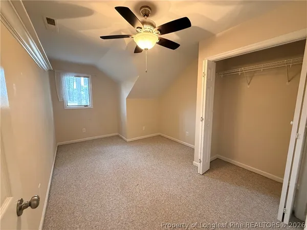 en empty room with windows and fan